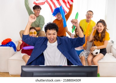 Group of Asian man and woman friends watching soccer games national competition on television with eating snack together at home. Sport fans people shouting and celebrating sport team victory match. - Shutterstock ID 2188004509
