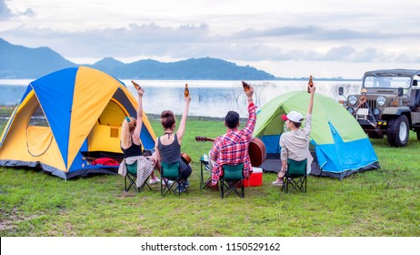 Group Asian Of Man And Women Have Friendship Enjoy Camping For Picnic And Barbecue At Lake With Tents On Background; Travel Concept And Happy Familly.