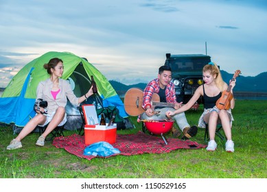 Group Asian Of Man And Women Have Friendship Enjoy Camping For Picnic And Barbecue At Lake With Tents On Background; Travel Concept And Happy Familly.