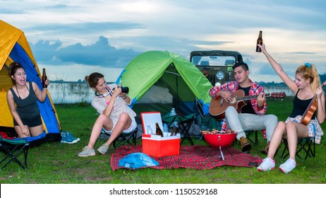 Group Asian Of Man And Women Have Friendship Enjoy Camping For Picnic And Barbecue At Lake With Tents On Background; Travel Concept And Happy Familly.