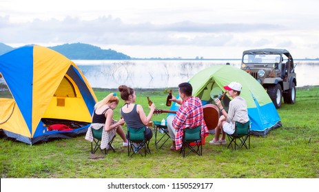 Group Asian Of Man And Women Have Friendship Enjoy Camping For Picnic And Barbecue At Lake With Tents On Background; Travel Concept And Happy Familly.