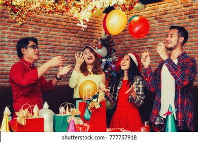 Group Of Asian Men And Women Enjoying Christmas Party In Holiday.