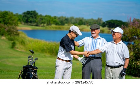 Group of Asian people businessman and senior CEO enjoy outdoor sport lifestyle golfing together at golf country club. Healthy men golfer shaking hand after finish game on golf course at summer sunset
