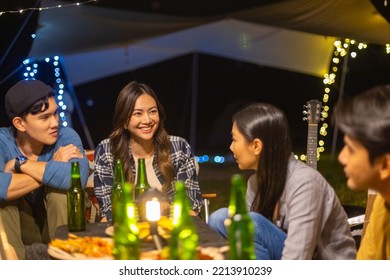 Group Of Asian People Enjoy And Fun Outdoor Lifestyle Hiking And Camping Together On Holiday Travel Vacation. Man And Woman Friends Having Dinner And Drinking Beer Together Near Tent In Summer Night.