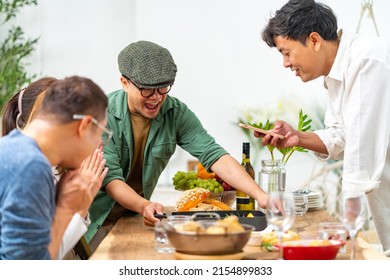 Group Of Asian People Friends Enjoy Dinner Party Eating Food And Drinking Wine On The Table With Talking Together At Home. Happy Man And Woman Reunion Dinner Meeting Celebration On Holiday Vacation