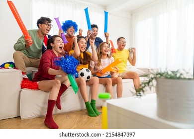 Group of Asian people friends sit on sofa watching and cheering soccer games competition on TV together at home. Happy man and woman sport fans shouting and celebrating sport team victory sports match - Shutterstock ID 2154847397