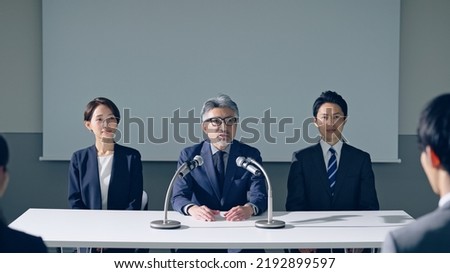 Group of Asian people giving a press conference