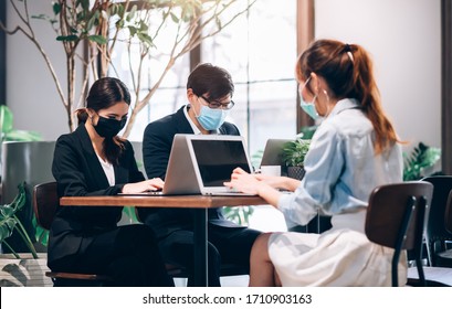 Group of Asian People  Successful Teamwork Businessman and Businesswoman Wearing Medical Mask Working with Laptop. Work from Private Home Office Social Distancing among Coronavirus Outbreak Situation	 - Powered by Shutterstock