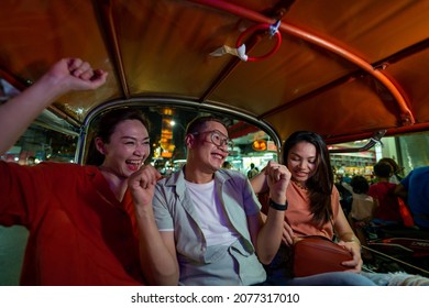 Group Of Asian People Tourist Traveling In Bangkok City By Tuk Tuk Taxi Car Together At Night. Male And Female Friends Enjoy And Having Fun Outdoor Lifestyle Travel City Street Nightlife In Thailand.