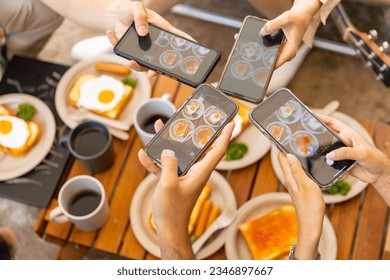 Group of Asian people using mobile phone photography meal during eating breakfast near the tent in the morning. Man and woman enjoy outdoor lifestyle travel nature camping on summer holiday vacation. - Powered by Shutterstock