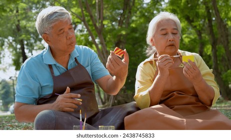 A group of Asian senior people enjoy painting cactus pots and recreational activity or therapy outdoors together  at an elderly healthcare center, Lifestyle concepts about seniority - Powered by Shutterstock