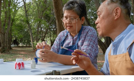 A group of Asian senior people enjoy painting cactus pots and recreational activity or therapy outdoors together  at an elderly healthcare center, Lifestyle concepts about seniority - Powered by Shutterstock