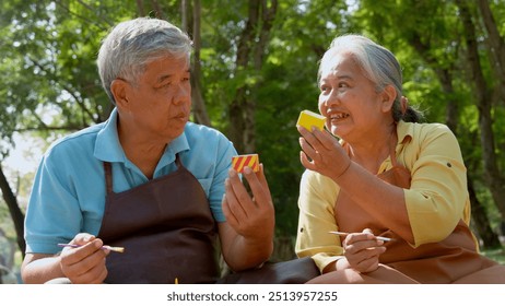 A group of Asian senior people enjoy painting cactus pots and recreational activity or therapy outdoors together  at an elderly healthcare center, Lifestyle concepts about seniority - Powered by Shutterstock