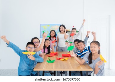 Group of asian students and a teacher showing their paper craft folding in classroom. - Shutterstock ID 1670897560