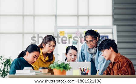 group of asian ux developer and ui designer serious brainstorming about mobile app interface on meeting table at modern office.Creative digital development agency