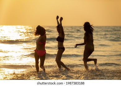 Group Of Asian Woman Friendship In Colorful Bikini Walking And Playing On The Beach Together At Summer Sunset. Female Girl Friends Enjoy And Having Fun Outdoor Activity Lifestyle On Summer Vacation
