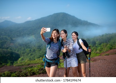 Group Of Asian Woman Hiker Taking Photo With Smart Phone At Mountain Peak