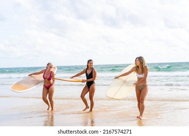 Group of Asian woman surfer in swimwear holding surfboard walking together on tropical beach at summer sunset. Female friends enjoy outdoor activity lifestyle water sport surfing on travel vacation - Powered by Shutterstock