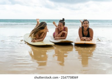 Group Of Asian Woman Surfer In Swimwear Relaxing On Surfboard After Surfing Together At Tropical Beach At Summer Sunset. Female Friends Enjoy Outdoor Lifestyle Water Sport Surfing On Travel Vacation