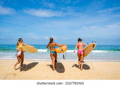 Group Of Asian Woman Surfer In Swimwear Holding Surfboard Walking Together On Tropical Beach In Sunny Day. Happy Female Friends Enjoy Outdoor Activity Lifestyle Water Sport Surfing On Summer Vacation