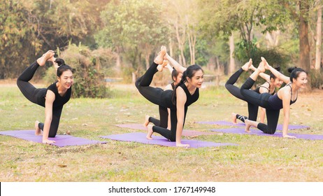 Group Of Asian Women Doing Yoga Beside The Lake In Outdoor Park.