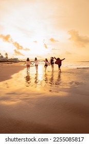a group of Asian women is running with their friends happily on the beach in the afternoon - Shutterstock ID 2255085817