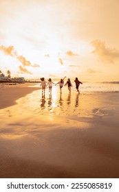 a group of Asian women is running with their friends happily on the beach in the afternoon - Shutterstock ID 2255085819