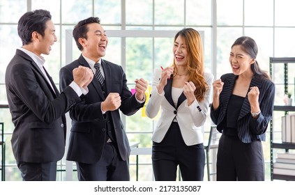 Group Of Asian Young Happy Cheerful Millennial Professional Successful Male Businessman Female Businesswoman Employee Colleague In Formal Suit Standing Smiling Holding Fists Up Celebrating Together.