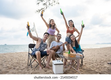 Group of Asian young man and woman having party on the beach together. Attractive happy friends traveler singing and dancing while camping at seaside enjoy holiday vacation trip in tropical sea island - Powered by Shutterstock