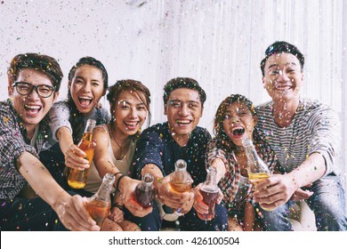 Group Of Asian Young People Clinking Bottles Of Beer With You