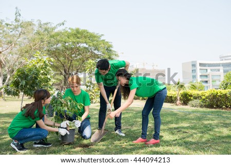 Group of Asian young people planting trees in city park