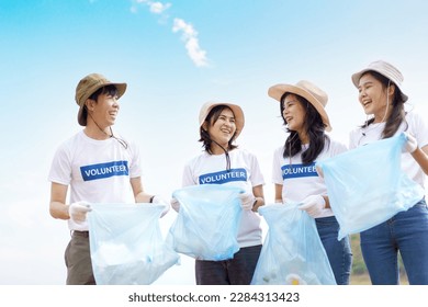 Group of Asian young people volunteer helping to collecting or picking up a plastic bottle garbage on the ground in park. Sustainability and environment conservation concept. - Powered by Shutterstock