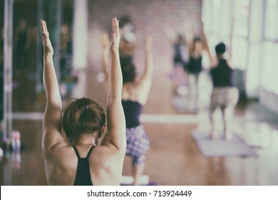 Group of asian young woman stretching and practices practicing during their yoga class in a gym. fitness, sport, training, yoga and people concept