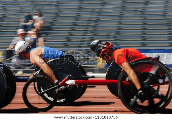 group athletes racer on wheelchair racing track\
stadium motion blurred