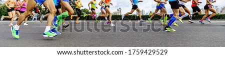 group athletes runners: men and women running city marathon in background of buildings