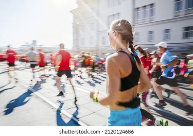 group athletes runners run marathon in sunlight - Shutterstock ID 2120124686