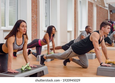 Group Of Athletic Sporty Men And Women Doing Stretching Exercise With Steppers