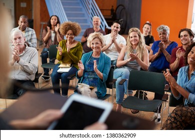 Group Attending Neighborhood Meeting Applauding Speaker In Community Center