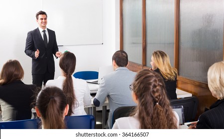 Group Of Attentive Adult Students With Teacher In Classroom At Business Training 
