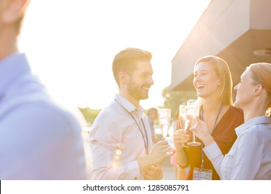 A group of attractive business colleagues enjoying a glass of champagne outside on a roof terrace in a restaurant or a bar. This could be a party, a convention, conference or a wedding event.