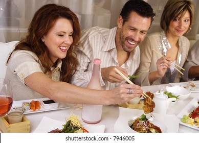 Group of attractive people eating and socializing at a restaurant