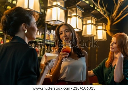 Group of Attractive woman enjoy and fun hangout nightlife meeting and drinking fancy cocktail together at luxury bar. Happy female friends celebrating holiday event party at nightclub in the city