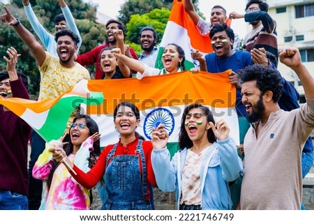 Group of audience at stadium shouting, screaming for win by holding indian flags while watching crcket sports match at stadium - concept of entertainment, championship tournament and entertainment