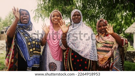 A Group of Authentic African Women in Traditional Clothes Waving and Smiling at the Camera. Friendly Female Rural Villagers Welcoming People in their Village with Big Smiles and Open Hearts