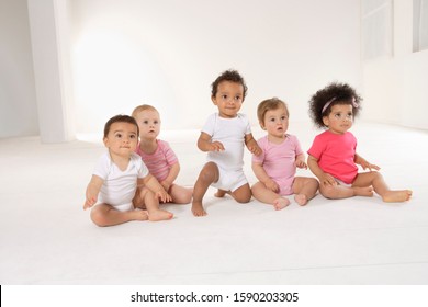 Group Of Babies Sitting On Floor