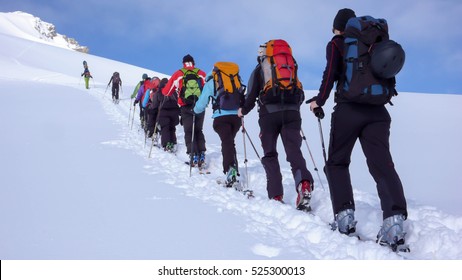 A Group Of Backcountry Skiers Climbing A Mountain In The Swiss Alps