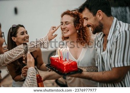 A group of beaming friends comes together to commemorate a special birthday, the air filled with excitement and merriment