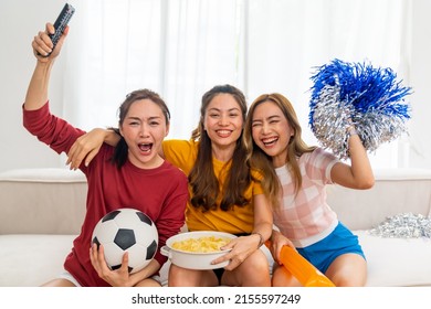 Group Of Beautiful Asian Woman Friends Sitting On Sofa Watching Soccer Game Competition On Television Together At Home. Happy Female Soccer Fans Cheering Victory Football Team Victory Sport Match