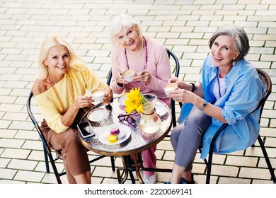 Group of beautiful and happy senior adult women dating outdoors and meeting at the bar cafeteria, having a talk - Stylish fashionable old mature people meeting and having fun in a cafe - Powered by Shutterstock