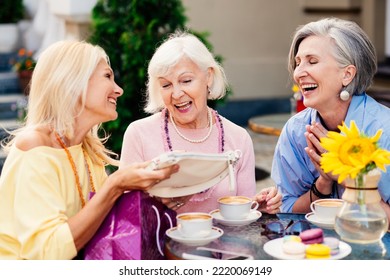 Group of beautiful and happy senior adult women dating outdoors and meeting at the bar cafeteria, having a talk - Stylish fashionable old mature people meeting and having fun in a cafe - Powered by Shutterstock